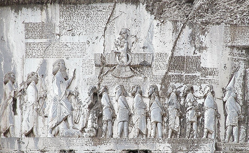 Rock relief of the Behistun inscription showing Darius I standing over defeated rebels