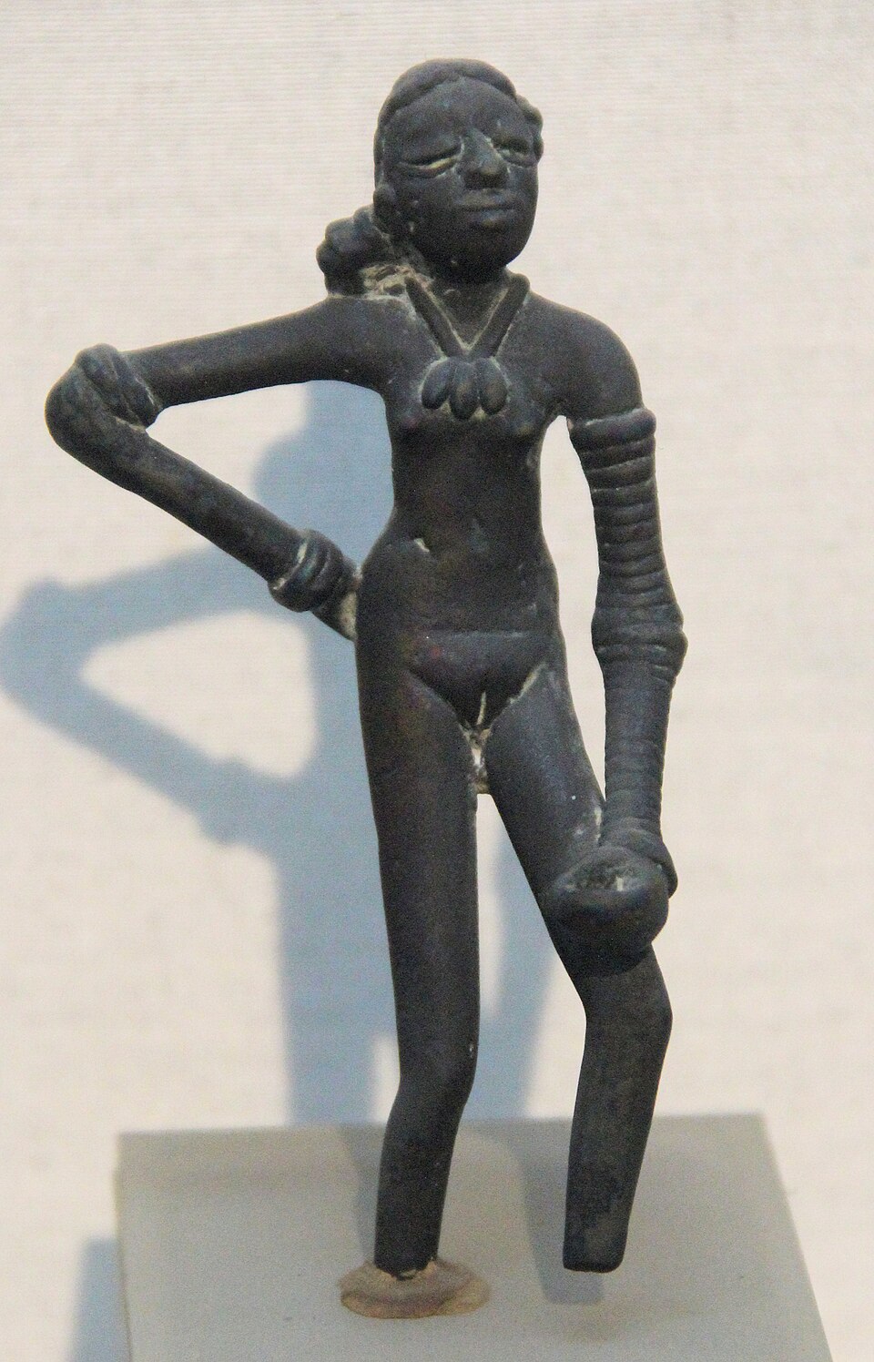 Bronze statuette of the Dancing Girl of Mohenjo-daro, a slender female figure with one hand on her hip