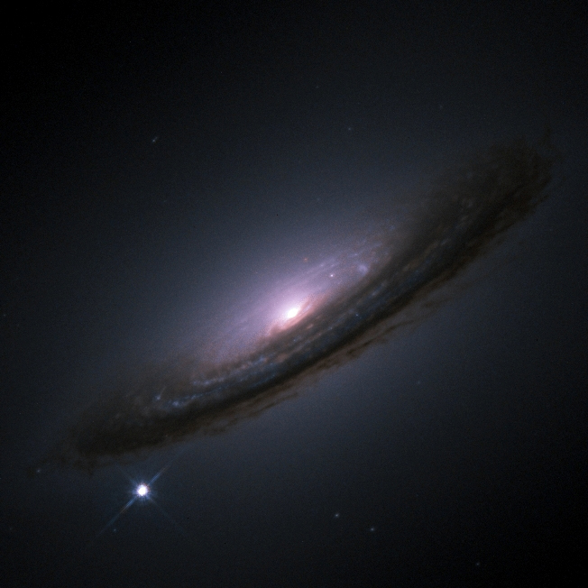 Hubble Space Telescope image of the Type Ia supernova SN 1994D appearing as a bright point of light at the lower left of the lenticular galaxy NGC 4526