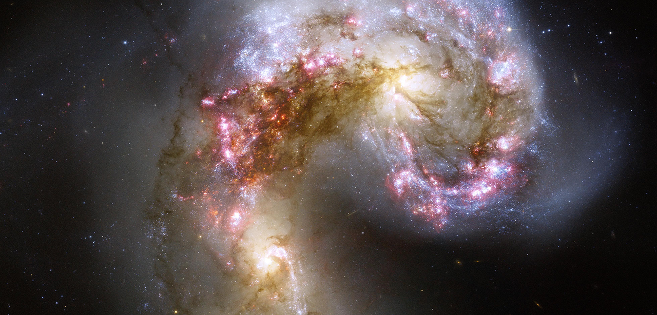 This celestial firestorm is the blazing wreckage of a collision between two spiral galaxies. The two galaxies, whose bright yellow cores appear to the