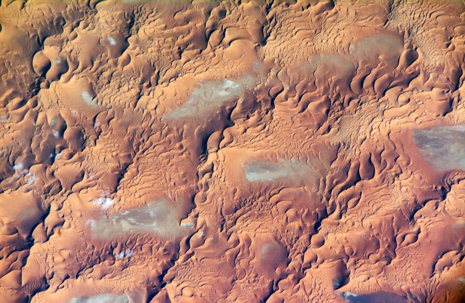Aerial view of the Issaouane Erg in eastern Algeria showing multiple dune types including linear, barchan, and star dunes