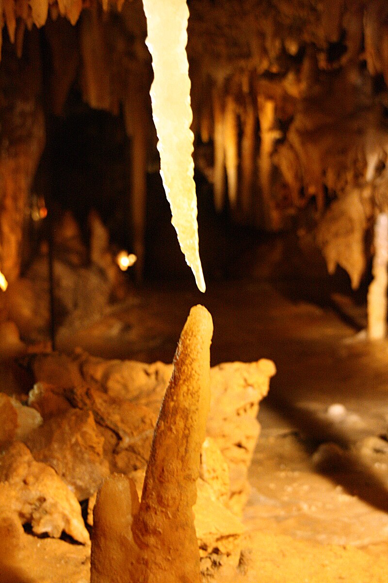 Stalactites hanging from cave ceiling and stalagmites rising from cave floor inside Grotte du Grand Roc in France