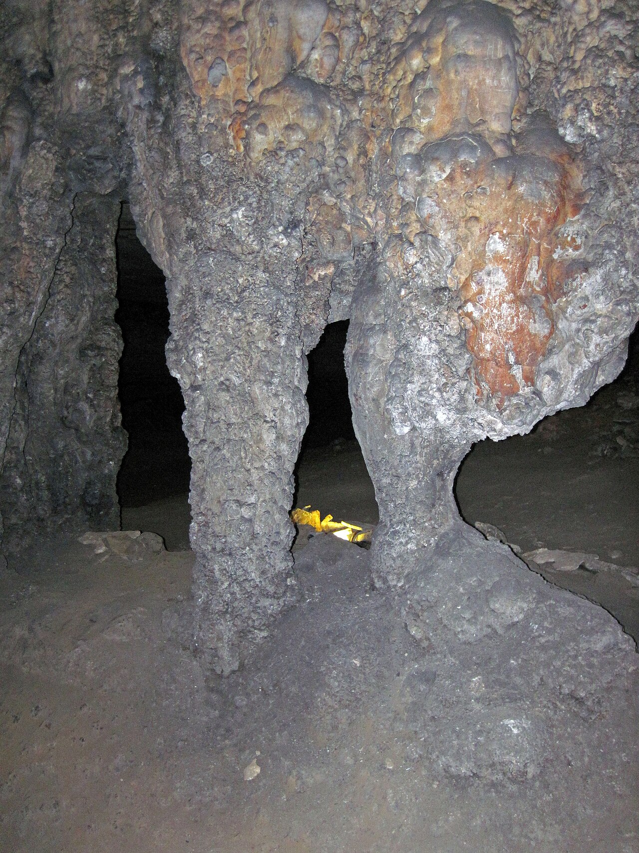A large stalagmite formation inside a limestone cave showing growth layers