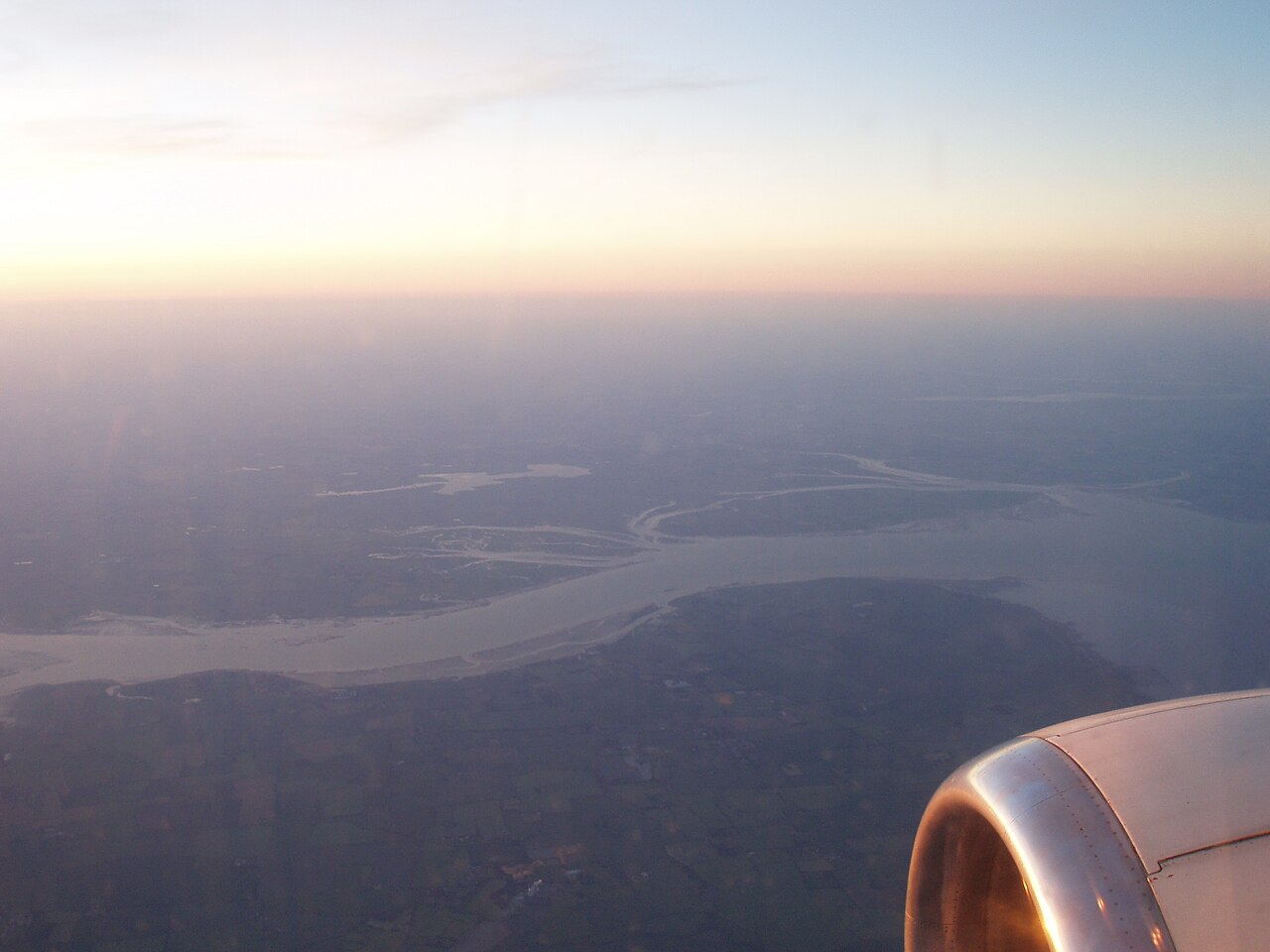 Aerial view of the Thames Estuary showing the transition from river to sea with tidal flats and marshlands