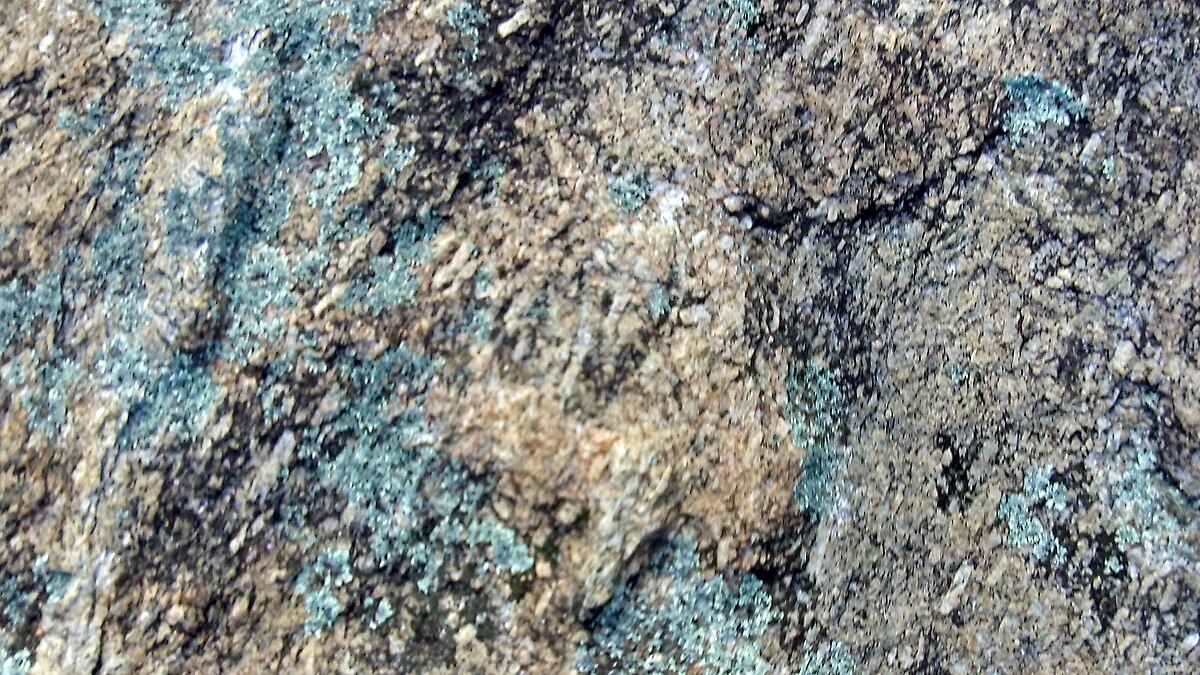 Closeup photograph of a granite surface showing interlocking crystals of quartz, feldspar, and mica