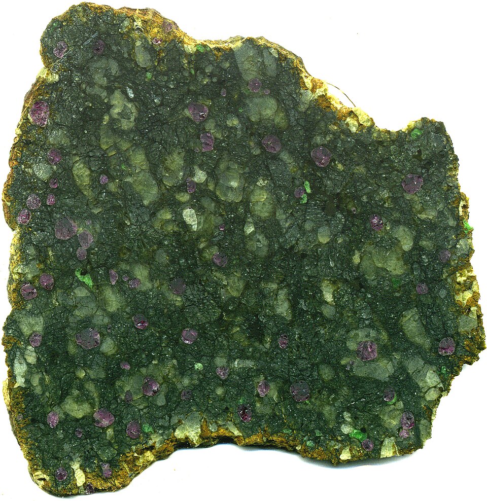 A garnet lherzolite xenolith from a kimberlite pipe at Kimberley, South Africa, showing dark olivine, purple pyrope garnet, and bright green chrome diopside