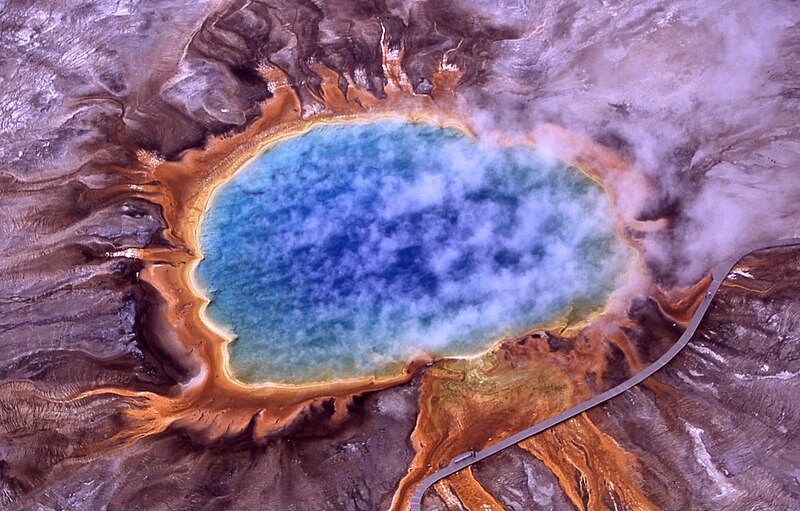 Aerial view of Grand Prismatic Spring in Yellowstone National Park, showing vivid blue, green, yellow, and orange colours