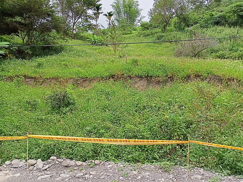 A rotational landslide on the Qingshan Industrial Road in Dakanuwa, Kaohsiung, Taiwan, showing a curved failure surface and backward-tilted head scarp