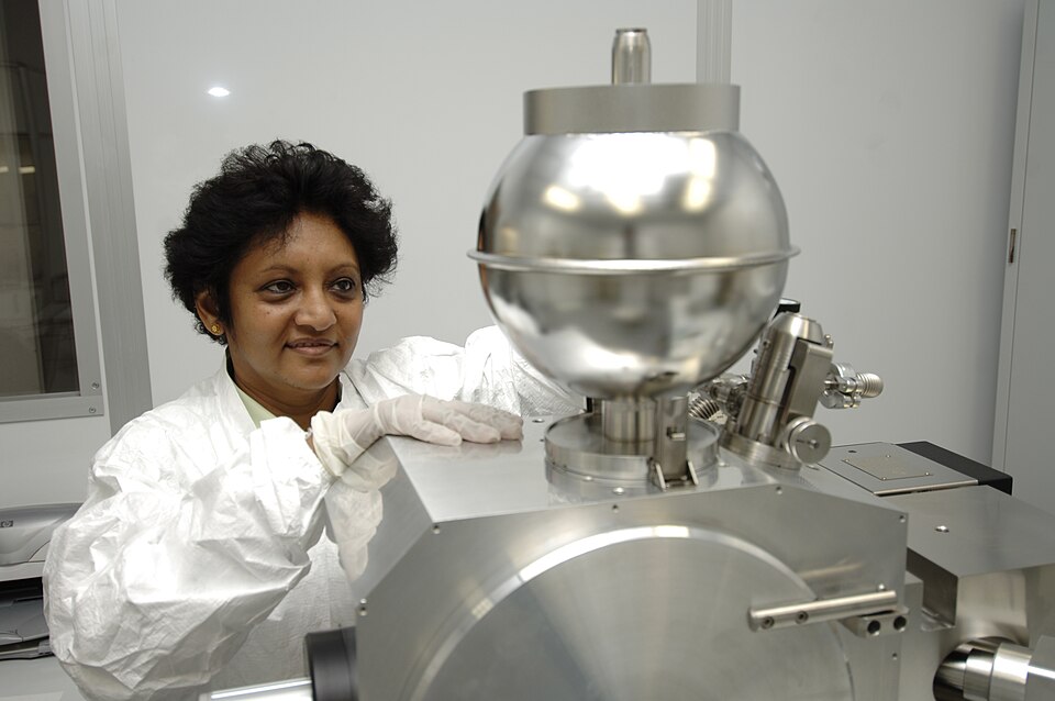 Technician operating a thermal ionization mass spectrometer in a clean laboratory