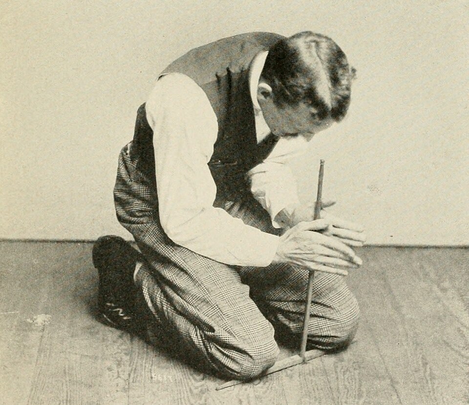 Illustration of fire making with a simple two-stick friction drill, one of the most widespread traditional methods of fire creation