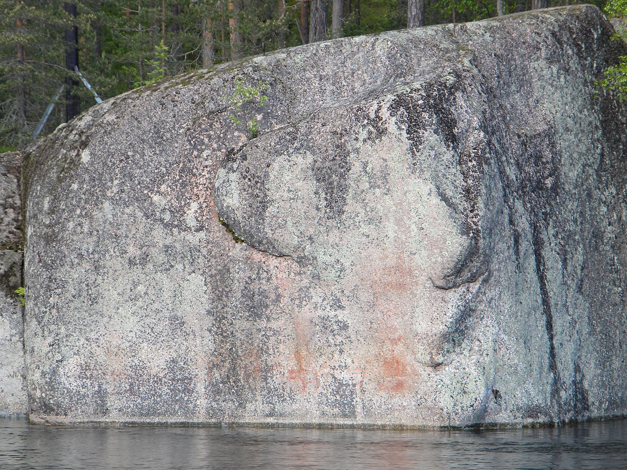 Stone Age rock painting made with red ochre pigment on a granite cliff face in Valkeala, Finland