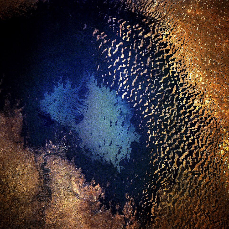 Satellite photograph of Lake Chad taken from the Space Shuttle, showing the lake's shallow basin surrounded by semi-arid landscape in the Chad Basin of central Africa