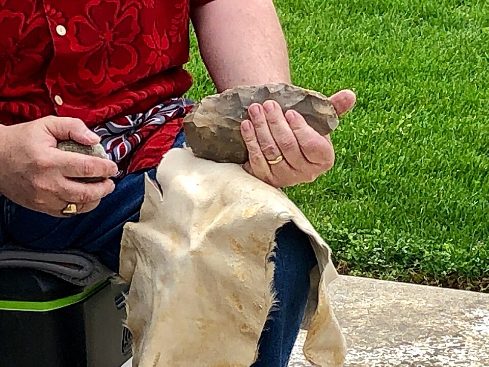 Nicholas Toth flaking stone to create an Acheulean handaxe replica, demonstrating the hierarchical planning required for Palaeolithic stone tool technology