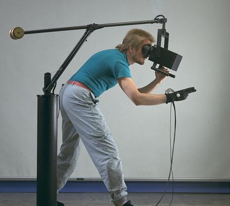 A researcher wearing a virtual reality headset and wired data gloves at NASA Ames Research Center